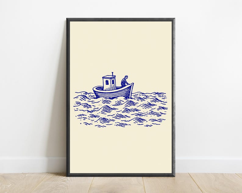 May include: A framed wall art print featuring a blue ink illustration on a cream background. The artwork depicts a small boat with a cabin floating on stylised, choppy ocean waves, with a figure visible inside the boat steering the vessel.