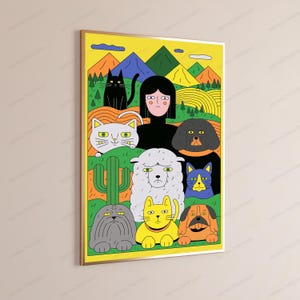 May include: A rectangular wall art print featuring a central figure with black hair surrounded by a collection of stylized cats, dogs, and a sheep. The background displays colorful mountains, rolling hills, and a green cactus in a vibrant yellow frame.
