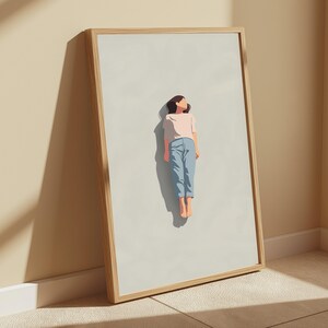 Pu&ograve; includere: Una stampa artistica incorniciata che presenta un'illustrazione minimalista di una persona che fluttua su uno sfondo grigio chiaro. La figura indossa una maglietta rosa pallido a maniche corte e pantaloni azzurri, con i piedi nudi. La cornice &egrave; in legno chiaro.
