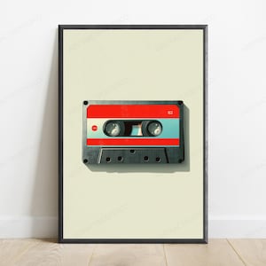 May include: A framed wall art print featuring a centered illustration of a vintage audio cassette tape. The cassette has a black plastic casing with a prominent red horizontal stripe across the top and middle sections, and the number 62 is printed.