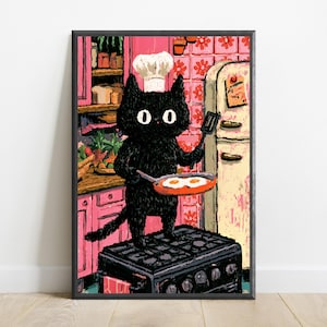 Peut inclure: Une impression d'art encadr&eacute;e repr&eacute;sentant un chat noir portant une toque de chef blanche, debout sur une cuisini&egrave;re noire dans une cuisine rose. Le chat tient une spatule et une po&ecirc;le contenant deux &oelig;ufs au plat. Fond avec placards roses.