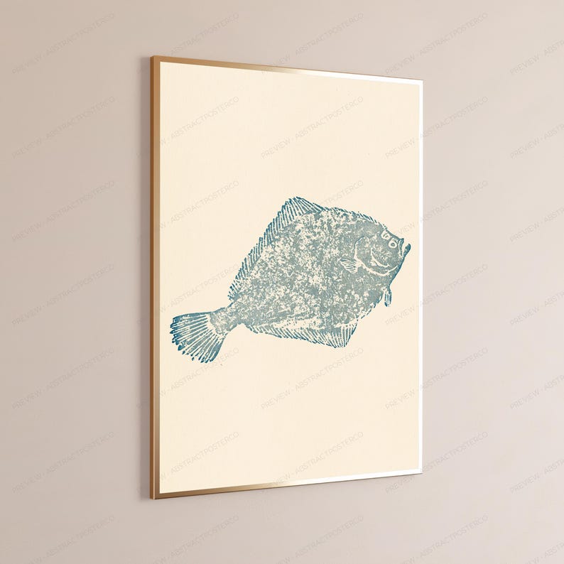 May include: A framed wall art print featuring a textured, blue-toned illustration of a flatfish centered on a solid cream-colored background. The artwork is enclosed in a thin, metallic gold frame, presenting a clean and simple visual composition.