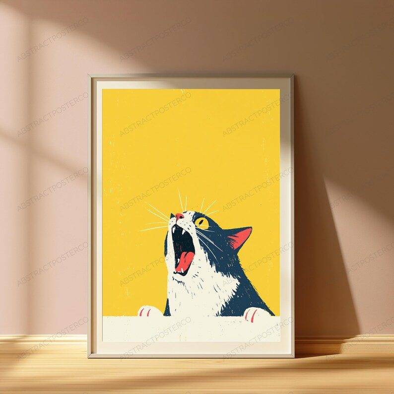 以下が含まれることがあります： 黄色い背景に、口を大きく開けた白黒の猫のイラストが描かれた額装アートプリント。猫は下端に配置され、歯と舌が見える状態で上を見上げている様子が描かれています。