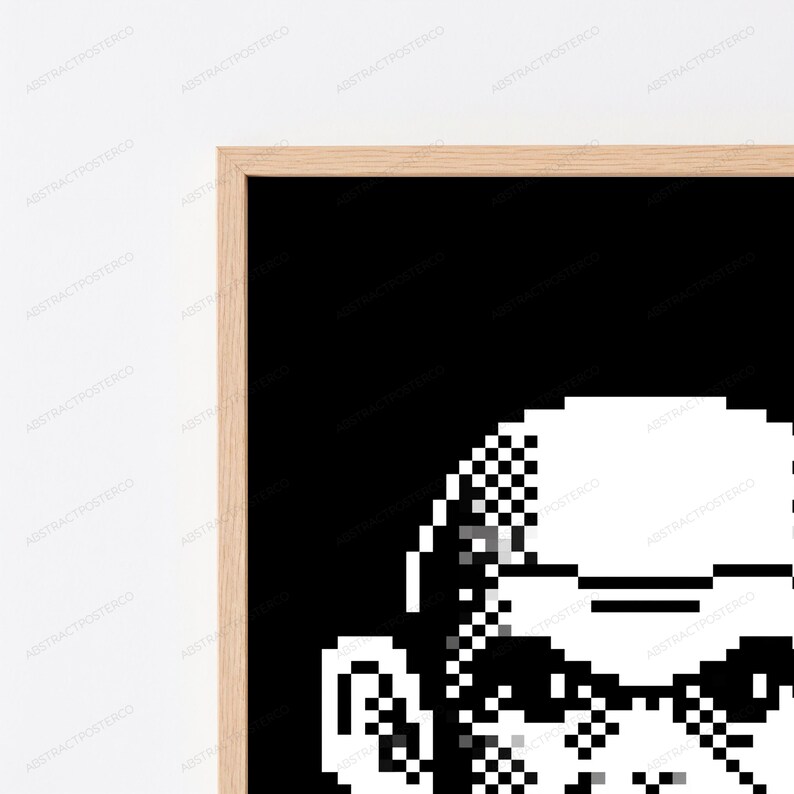 May include: A framed wall art print featuring a high-contrast, black and white pixel art graphic. The design displays a stylized, blocky character portrait composed of square pixels against a solid black background, encased in a light wood frame.