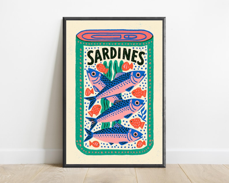 May include: A rectangular art print featuring a stylized illustration of an open tin of sardines. The design includes three large blue and pink fish, several smaller orange fish, and green seaweed accents on a cream background with the text SARDINES.