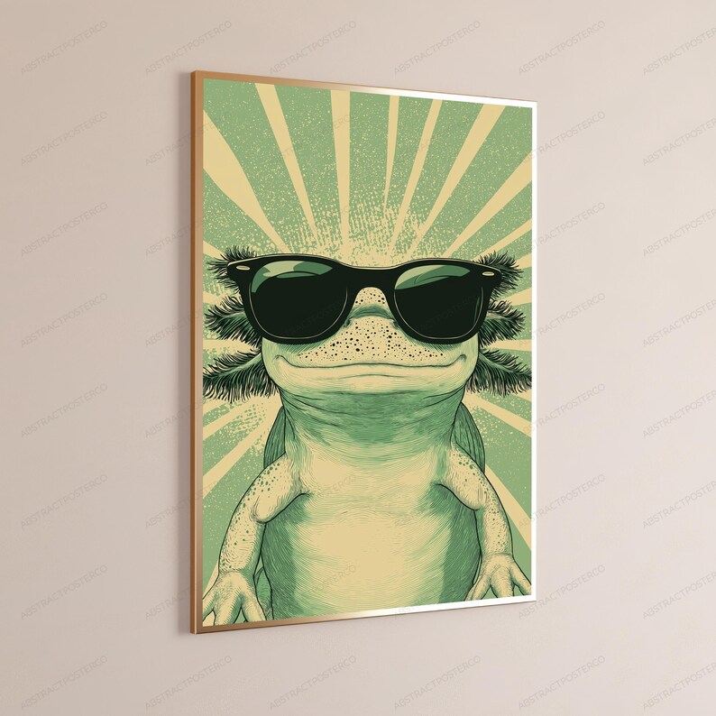 May include: A framed vertical wall art print featuring a stylized illustration of an axolotl wearing black sunglasses. The axolotl is light green with darker green shading and a sunburst background pattern in shades of pale yellow and green.
