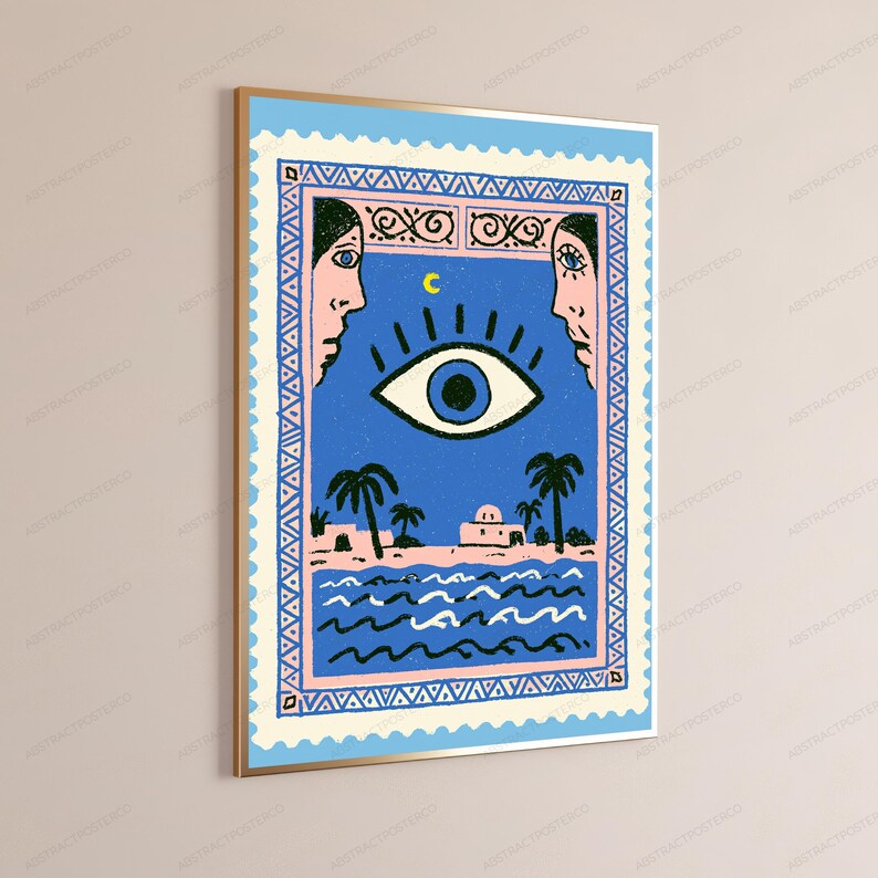 May include: A rectangular wall art print framed in gold, featuring a blue postage stamp design. The illustration depicts a large central eye, a yellow crescent moon, two side profiles, palm trees, a building, and wavy water patterns.