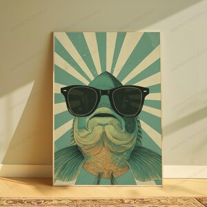 May include: A rectangular wall art print featuring a stylized illustration of a fish wearing large black sunglasses. The fish is centered against a background of radiating light teal and cream-colored sunburst lines with a subtle dot pattern.