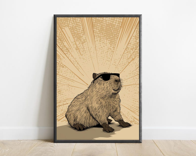 May include: A framed wall art print featuring a detailed illustration of a brown capybara wearing black sunglasses. The background consists of a light tan color with radiating sunburst lines and a subtle dot pattern, all enclosed in a black frame.
