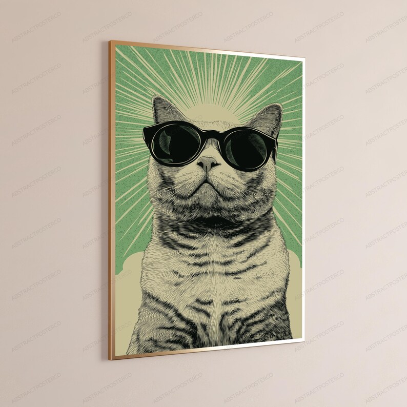 May include: A framed wall art print featuring a detailed illustration of a tabby cat wearing large black sunglasses. The cat is centered against a light green background with radiating white sunburst lines extending from behind its head.