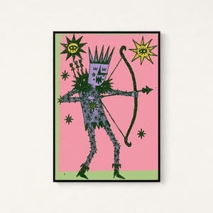 K&ouml;nnte beinhalten: Ein gerahmter Kunstdruck auf rosa Hintergrund mit einer violetten Figur, die eine Krone tr&auml;gt und einen Pfeil und Bogen h&auml;lt. Die Figur ist von gr&uuml;nen Sternen und zwei Sonnen mit Augen umgeben. Die Illustration hat eine texturierte, dunkelgr&uuml;ne Kontur.