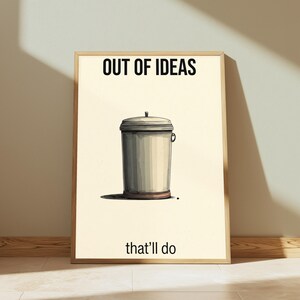 K&ouml;nnte beinhalten: Ein gerahmtes Poster mit cremefarbenem Hintergrund und einer zentralen Illustration eines grauen Metallm&uuml;lleimers. Der Text "OUT OF IDEAS" ist oben in Schwarz gedruckt, und der Text "that'll do" ist unten auf dem Poster in Schwarz gedruckt.