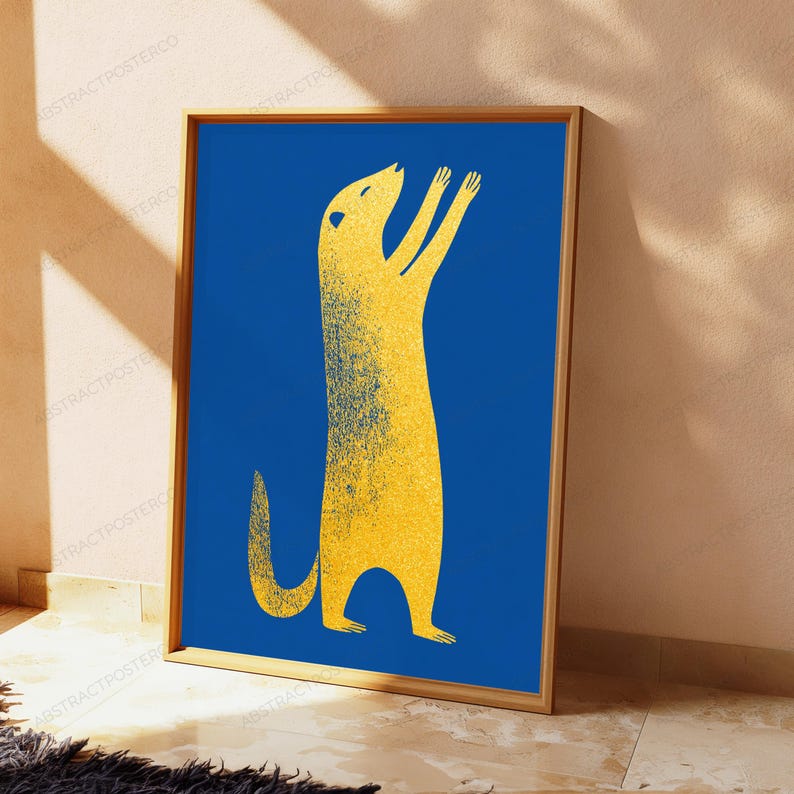 K&ouml;nnte beinhalten: Ein rechteckiger gerahmter Kunstdruck mit der stilisierten Silhouette eines gelben Erdm&auml;nnchens mit k&ouml;rnigem Textureffekt vor einem einfarbigen, tiefblauen Hintergrund. Das Erdm&auml;nnchen steht aufrecht mit erhobenen Vorderpfoten.
