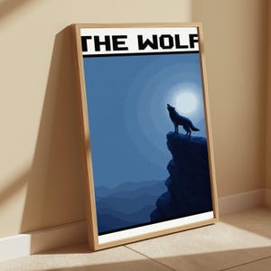 May include: A framed vertical poster featuring a pixelated graphic of a wolf howling at a full moon from a rocky cliff. The artwork uses shades of blue and black, with the text THE WOLF printed in a bold, black pixelated font at the top.