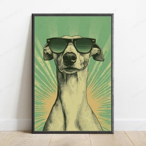 May include: A framed wall art print featuring a stylized illustration of a greyhound dog wearing dark sunglasses. The dog is centered against a green background with a radiating sunburst pattern in a lighter yellow-green hue behind the head.