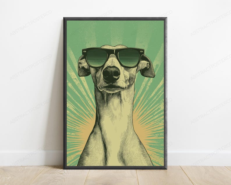 May include: A framed wall art print featuring a stylized illustration of a greyhound dog wearing dark sunglasses. The dog is centered against a green background with a radiating sunburst pattern in a lighter yellow-green hue behind the head.