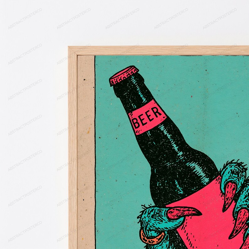 May include: A framed art print featuring a black beer bottle with a pink label that reads BEER in black text. The bottle is held by a textured, teal-coloured clawed hand with pink fingernails, set against a solid teal background.