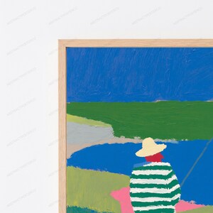 Op de afbeelding: Een ingelijst schilderij met een figuur die een strokleurige hoed en een groen-wit gestreept shirt draagt, bij een blauw wateroppervlak. Het landschap bevat stukken groen gras, een grijs gedeelte en een helderblauwe lucht boven het geheel.