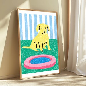 May include: A framed wall art print featuring a yellow dog sitting on a green surface in front of a light blue and white striped background. In the foreground, there is a pink circular object with a blue centre, rendered in a crayon style.