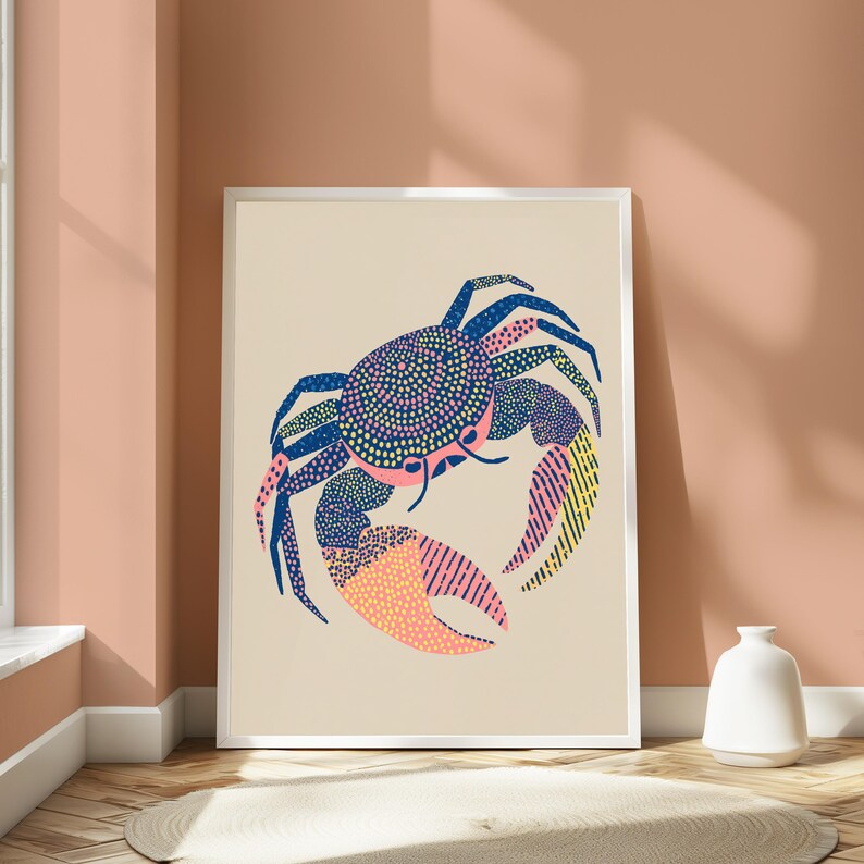 May include: A framed wall art print featuring a stylized crab illustration on a light beige background. The crab is rendered in dark blue, pink, and yellow, with intricate patterns of dots and lines covering its shell and large pincers.