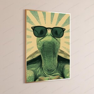 May include: A rectangular wall art print featuring a green turtle wearing black sunglasses. The turtle is centered against a background of radiating light yellow and green dotted sunburst lines, creating a graphic illustration with a vintage aesthetic.