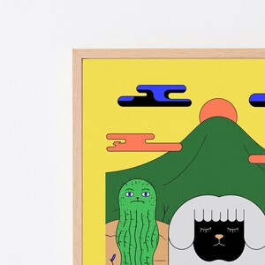 May include: A framed art print featuring a yellow sky with a red sun, a green mountain, and stylized clouds. In the foreground, a green cactus with purple eyes stands next to a white sheep with a black face and closed eyes on a tan ground.