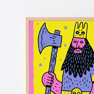 以下が含まれることがあります： ピンクの顔、長い黒い髭、黄色い王冠をかぶった王の様式化されたイラストが描かれた額装アートプリント。人物は、小さな青い星と紙吹雪のアクセントがある明るい黄色の背景に対して、大きな紫色の斧を持っています。