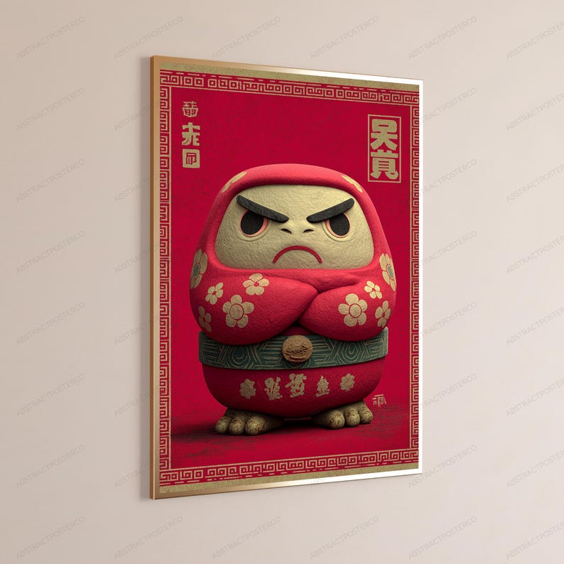 Peut inclure: Une affiche encadr&eacute;e repr&eacute;sentant une poup&eacute;e Daruma rouge avec un visage cr&egrave;me textur&eacute;, les bras crois&eacute;s et des motifs floraux dor&eacute;s. Le fond est rouge profond avec une bordure d&eacute;corative et des caract&egrave;res asiatiques dor&eacute;s en haut et en bas.