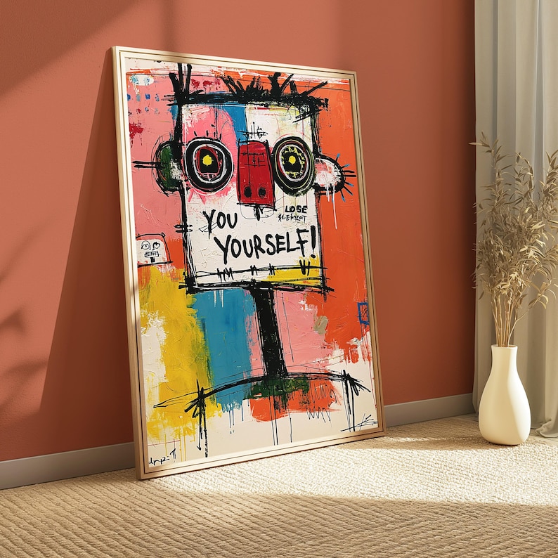 May include: A rectangular framed wall art piece featuring a stylized, abstract face with bold black outlines, large circular eyes, and a red nose. The background is a vibrant mix of orange, yellow, pink, and blue paint, with the text YOU YOURSELF!