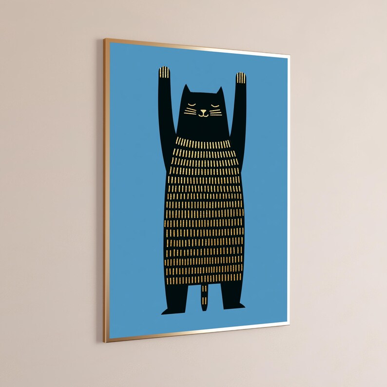 Op de afbeelding: Een ingelijste muurkunstprint met een zwarte kat met opgeheven armen tegen een effen blauwe achtergrond. De kat heeft een goudkleurig lichaam met verticale streepjes en een eenvoudig gouden gezicht. De lijst is dun en heeft een metaalkleur.