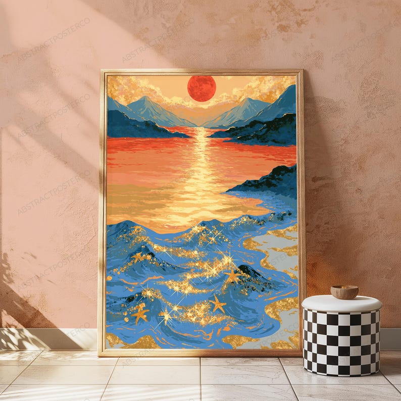May include: A framed vertical wall art print depicting a landscape with a large red sun setting over blue mountains and a calm orange sea. The foreground features dark blue ocean waves with gold glitter accents and several gold starfish shapes.