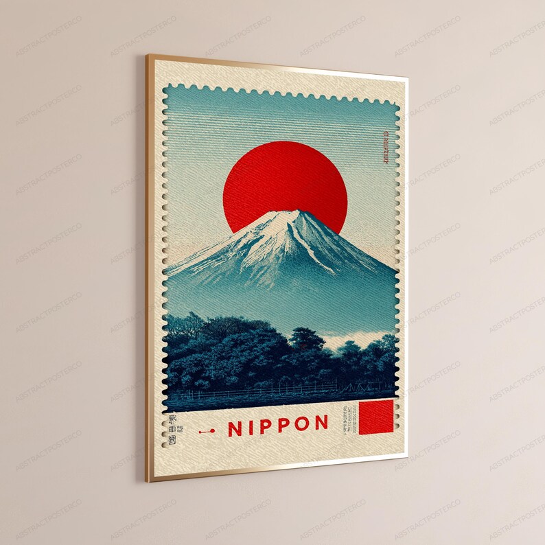 K&ouml;nnte beinhalten: Ein rechteckiger Wandkunstdruck im Design einer Briefmarke mit einer gro&szlig;en roten Sonne &uuml;ber dem schneebedeckten Berg Fuji. Am Fu&szlig; des Berges sind dunkelblaue B&auml;ume zu sehen. Der Text NIPPON ist unten in Rot neben einem roten Quadrat gedruckt.