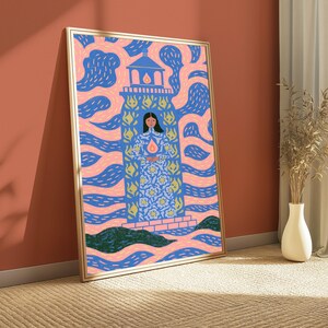 May include: A framed rectangular wall art print featuring a stylised illustration of a person standing inside a blue lighthouse structure. The background consists of swirling pink and blue patterns, with a small flame icon centred on the person's chest.