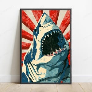 May include: A framed vertical poster featuring a stylized illustration of a great white shark with its mouth wide open, revealing sharp teeth. The background consists of bold, radiating red and off-white stripes with a distressed, weathered texture.