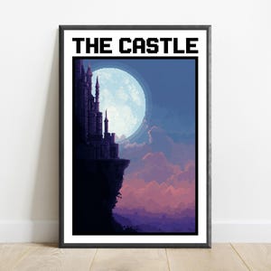 Puede incluir: Una impresi&oacute;n de arte pixel enmarcada titulada THE CASTLE, que muestra la silueta oscura de un castillo sobre un acantilado frente a una gran luna llena brillante. El cielo cambia de azul profundo a nubes rosas y p&uacute;rpuras sobre el paisaje.