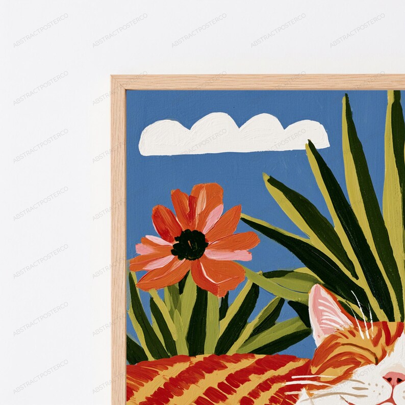 Puede incluir: Una l&aacute;mina de arte enmarcada que muestra un gato atigrado naranja en primer plano, una flor grande de color naranja, hojas tropicales verdes y una nube blanca sobre un cielo azul s&oacute;lido. El marco es de madera clara con veta natural.