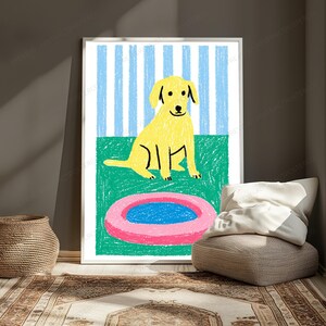May include: A framed wall art print featuring a yellow dog sitting on a green surface in front of a light blue and white striped background. In the foreground, there is a pink circular object with a blue centre, all rendered in a crayon style.