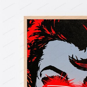 May include: A framed wall art print featuring a high-contrast graphic illustration. The artwork displays bold black and vibrant red stylized shapes against a light gray background, enclosed within a simple, light-toned wooden frame.