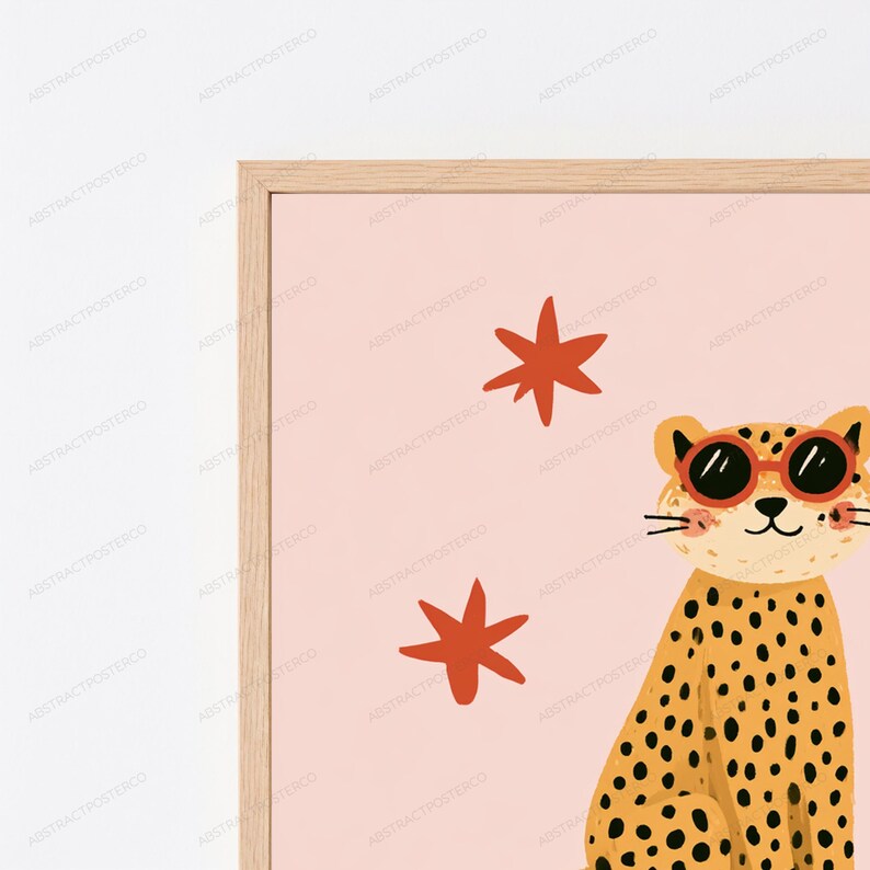Op de afbeelding: Een ingelijste kunstdruk met een cartoonluipaard met zwarte vlekken, die een zonnebril met rode randen draagt, tegen een lichtroze achtergrond met twee oranje stervormige iconen. De lijst is gemaakt van lichtgekleurd hout met een dun profiel.