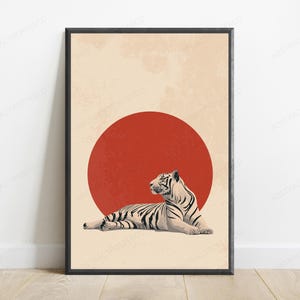 Puede incluir: Una l&aacute;mina de arte mural enmarcada que muestra un tigre blanco con rayas negras tumbado frente a un gran c&iacute;rculo rojo s&oacute;lido. El fondo es de color beige claro con una textura sutil y desgastada, todo dentro de un marco negro fino.
