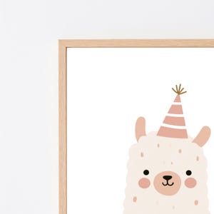以下が含まれることがあります： ピンクと白のストライプのパーティーハットをかぶった、クリーム色のラマが描かれた額入りウォールアートプリント。ラマには2つの小さな黒い目、ピンクの鼻、バラ色のピンクの頬があり、明るい木製のフレームの中で白い背景に配置されています。