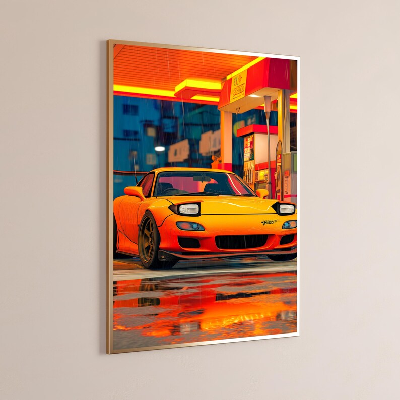 K&ouml;nnte beinhalten: Ein gerahmter Kunstdruck, der einen leuchtend orangefarbenen Sportwagen mit Klappscheinwerfern an einer Tankstelle unter einem gelben Vordach zeigt. Die Szene stellt einen regnerischen Abend mit Spiegelungen auf dem nassen Boden dar.
