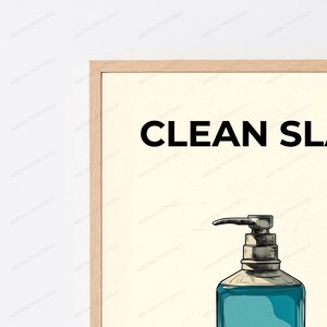 May include: A framed wall art print featuring a light cream background with the black text CLEAN SLATE at the top. Below the text is a detailed illustration of a teal liquid soap dispenser with a metallic pump mechanism and dark outlines.