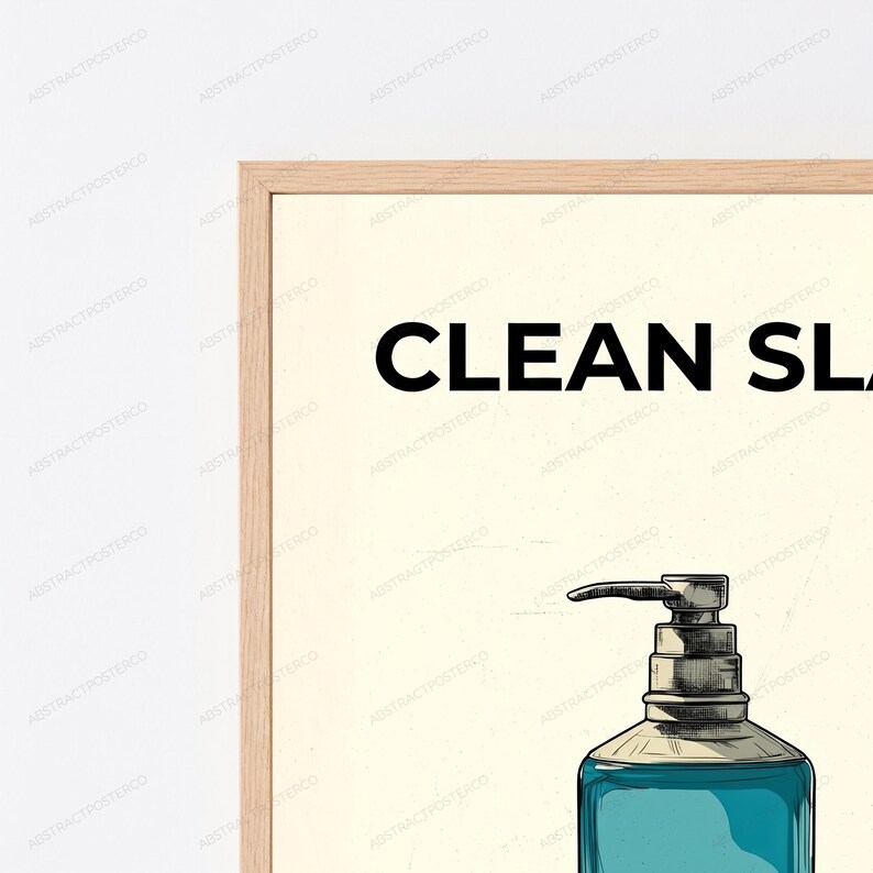 May include: A framed wall art print featuring a light cream background with the black text CLEAN SLATE at the top. Below the text is a detailed illustration of a teal liquid soap dispenser with a metallic pump mechanism and dark outlines.