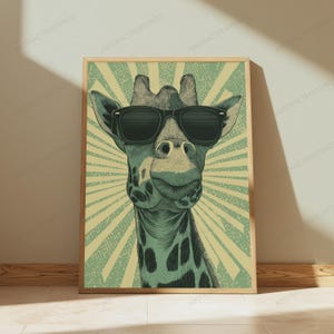 May include: A framed wall art print featuring a stylized illustration of a giraffe wearing black sunglasses. The giraffe is centered against a light green background with a radiating sunburst pattern in a darker shade of green and cream.