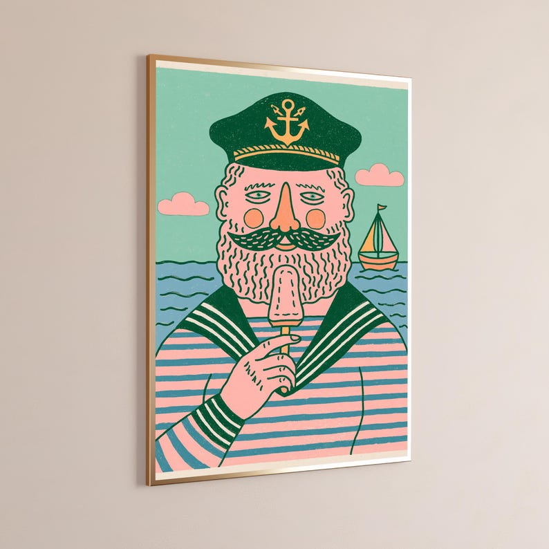 K&ouml;nnte beinhalten: Ein gerahmter Kunstdruck zeigt einen b&auml;rtigen Seemann mit einer dunkelgr&uuml;nen Kapit&auml;nsm&uuml;tze mit gelbem Ankeremblem und einem rosa-blau gestreiften Hemd. Der Seemann isst ein Eis vor einem hellgr&uuml;nen Hintergrund mit einem kleinen Segelboot.