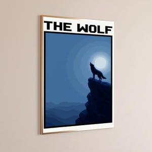 May include: A rectangular wall art print featuring the text THE WOLF in black pixelated font at the top. The illustration depicts a dark blue silhouette of a wolf standing on a rocky cliff, howling toward a bright circular moon in a night sky.