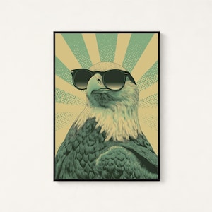 May include: A framed wall art print featuring a detailed illustration of a bald eagle wearing black sunglasses. The eagle is centered against a background of alternating light yellow and teal sunburst rays with a subtle dot pattern texture.