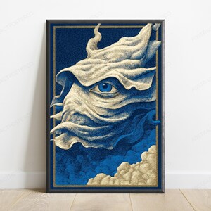 May include: A framed vertical art print featuring a stylized, cream-colored, flowing fabric-like form with a single, detailed blue eye at its center. The background is a deep navy blue with textured clouds at the bottom, all enclosed in a gold border.