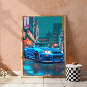 May include: A rectangular framed wall art print featuring a bright blue sports car parked on a wet city street at night. The scene is set against a backdrop of tall buildings with glowing neon signs and vertical Japanese text in a rainy atmosphere.